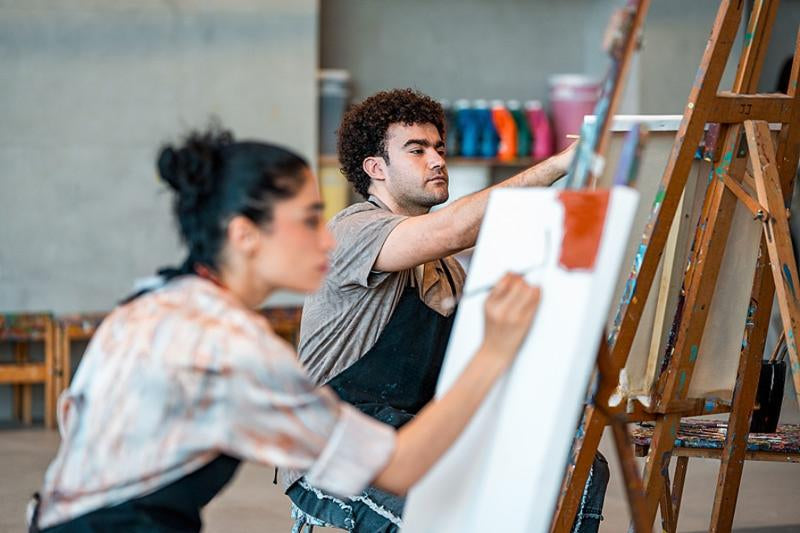 Artistes peignant à l’huile d’après image à l’atelier